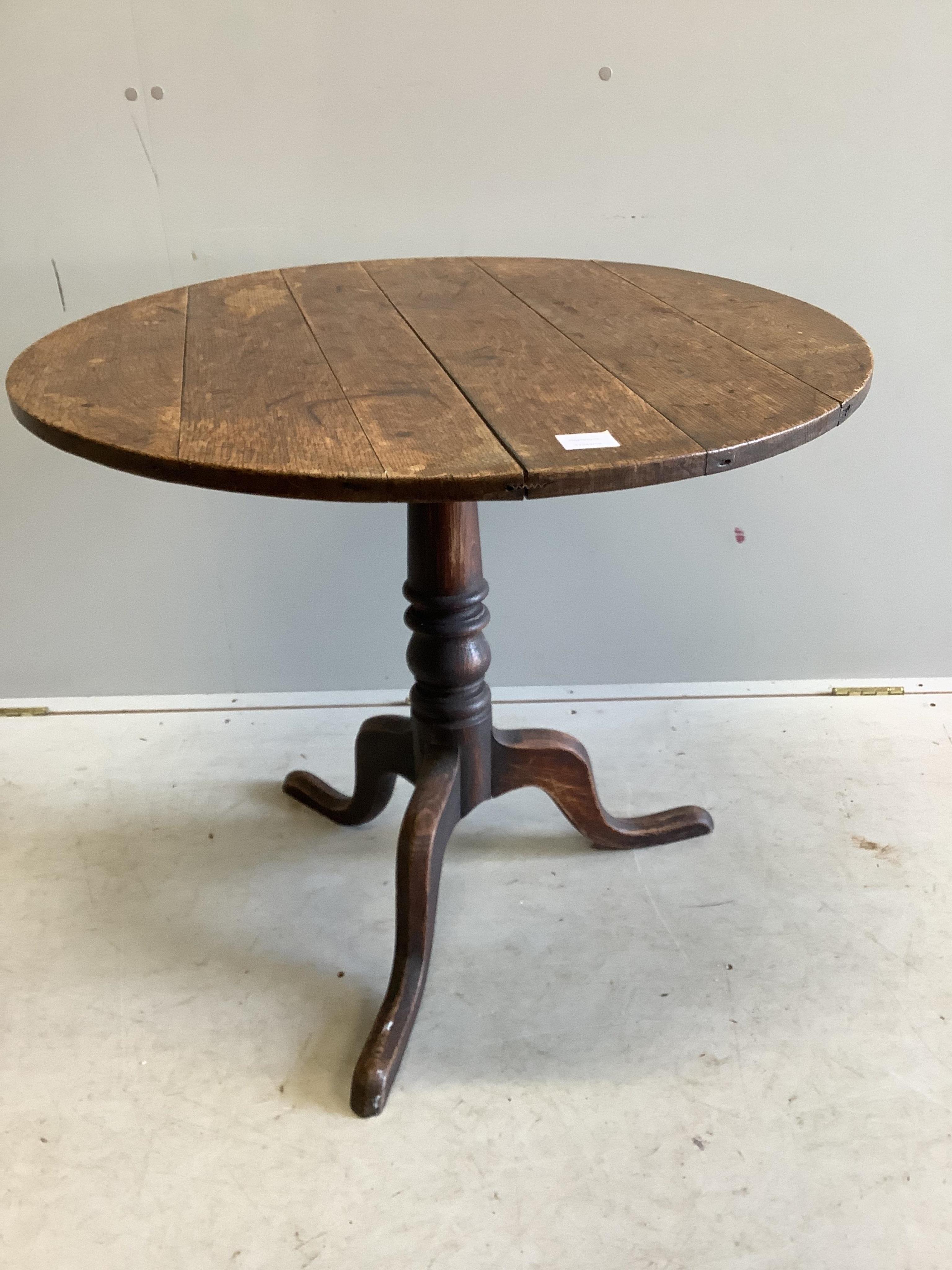 A George III circular oak tilt top tripod table, diameter 82cm, height 70cm. Condition - fair